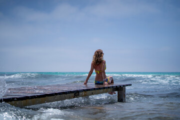 Woman sitting on beach walkway on the island of Formentera