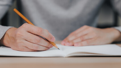 Close up hands of man holding pencil with writing on notebook, Learn from home, Work from home