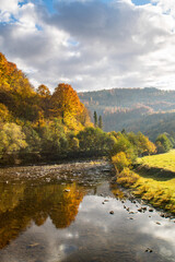river on the background of autumn forest and mountains at sunrise. fall nature, fall countryside, second summer.