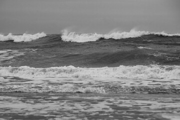 Scenic grayscale shot of sea waves washing the shore
