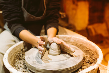 female hands of pottery master close-up work behind potter's wheel. Master class for manufacture of handcrafted ceramic products