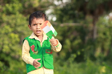 little indian boy proudly holding Tricolour Indian National flag.