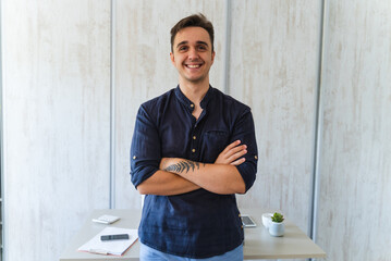 Man standing with crossed hands in his home office