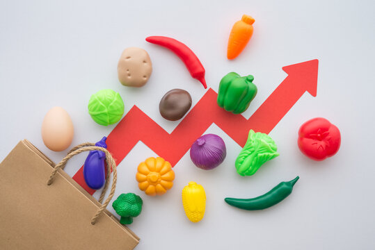 Vegetables, egg, paper bag and price graph rising up on white background. Food price increase due to supply shortage of fertilizer and animal feed, economic inflation and ukraine vs russia war concept - Powered by Adobe