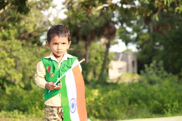 little indian boy proudly holding Indian National flag. The national flag of India, colloquially...