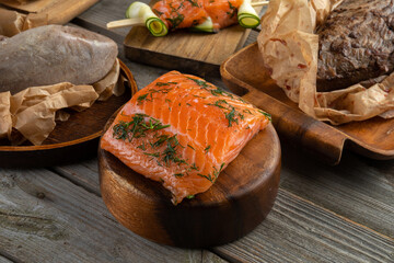 Salmon fish. Uncooked salmon fillet with lemon sea salt and dill on wooden plank.