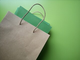 Paper shopping bag with books on green background