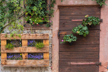Detail of a house facade decorated with flowers with a wooden door in Bad Orb/Germany in the Spessart