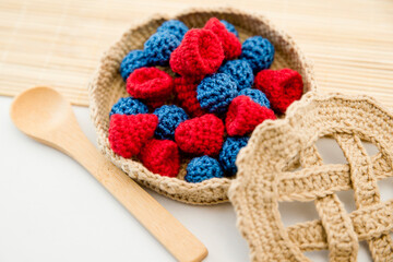 Making a toy pie with forest berries in an ancient style crocheted basket. Hand made material for toddlers Home cooking games. Sensory implement to develop child's imagination and fine motor skills.
