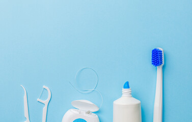 Toothbrush with toothpaste and dental floss on a blue background. Template Copy space for text....