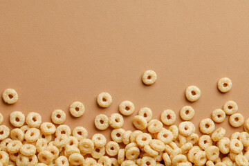 Cornflakes rings for breakfast on a brown background.