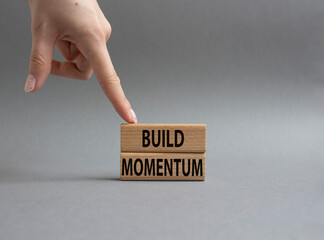 Build momentum symbol. Wooden blocks with words Build momentum. Beautiful grey background. Businessman hand. Business and Build momentum concept. Copy space.