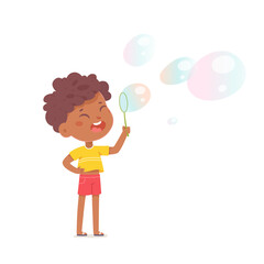 Cute boy blowing soapy bubbles, funny kid holding blower maker stick in hand to blow