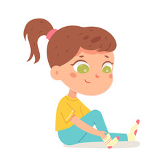 Cute girl putting on sock, isolated adorable kid sitting on floor to put foot underwear