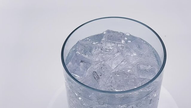 Closeup view of sparkling cold soft drink, carbonated liquid and cool iced cubes in a glasses. Soda fizzy drink frozen cubes in transparent glass. Refreshing cocktails and beverages