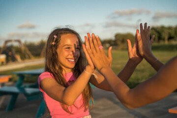 Teenage best friends performing hand clapping game and enjoying of the summer