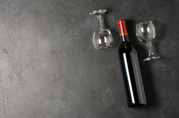 Obraz na płótnie Canvas Red wine in a bottle. Black concrete background. Flat lay. Copy space.