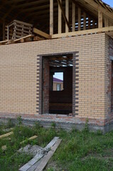 Obraz premium Construction of a brick and wooden roof house construction in progress