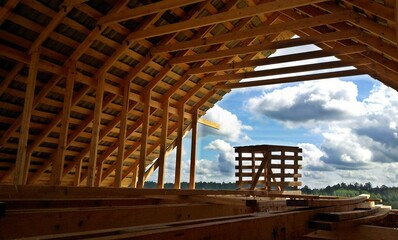 Fototapeta premium Construction of a brick and wooden roof house construction in progress