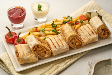Arabic Shawarma with fries, ketchup, raita served in a dish isolated on grey background side view of fastfood
