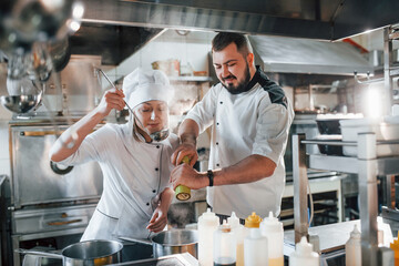 Man and woman cooking meal. Professional chef preparing food in the kitchen