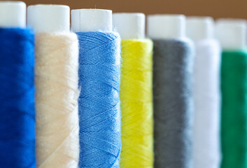 macro photography of multi-colored skeins of thread for sewing