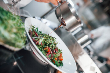 Close up view of vegetarian salad. Professional chef preparing food in the kitchen
