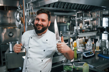 Fototapeta na wymiar With sharp knives. Professional chef preparing food in the kitchen