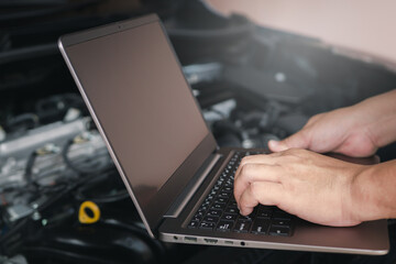 Mechanic using computer laptop for diagnostics engine. Repairing car Check various operating systems to check for abnormalities, service concept and technology