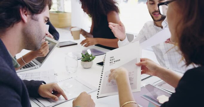 Group of diverse colleagues meet, discuss paperwork and talk strategy to improve business productivity. Serious business professionals plan while going through documents and reports together