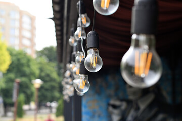 Close up of retro light bulb string used as outdoor decoration. Selective focus. Low DOF.