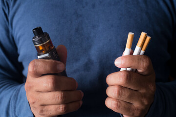 Concept of choosing the type of cigarette, a man's hand holds both types of cigarettes to choose...