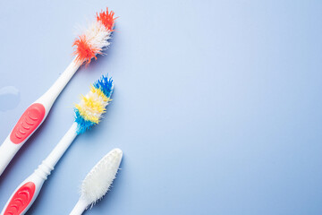 Used old toothbrush on blue background. Dental care concept. copy space