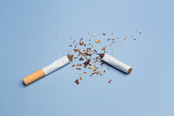 Cigarettes are destroyed on a blue background. Smoking cessation concept. Copy Space