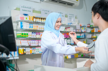 Female muslim pharmacist counseling customer about drugs usage in a modern pharmacy drugstore.