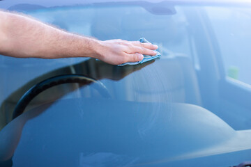 close-up man washes the glass of the car at the car wash