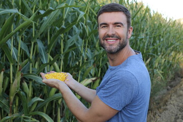 Farmer in beautiful corn fields showing organic product 
