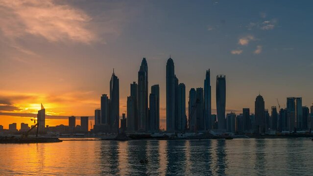 Time lapse of  sunrises behind high rise building  in Dubai Marina.