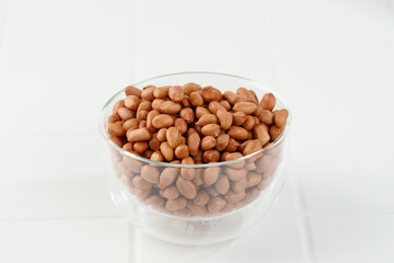 Raw  Peanuts on Clear Bowl, on White Table