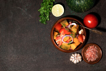 Healthy food pumpkin tomato salad on metal background top view.