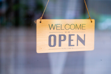 A business sign hangs door sign open sign on glass door cafe cafe coffee shop business owner food. 