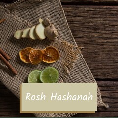 Composite of rosh hashanah text with ginger, lemon, lime slices and cinnamon on table
