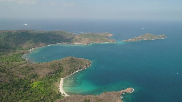 Aerial view coastline with tropical beach, island Limbones, lagoons and coral reefs. Neela cove, Philippines, Luzon. Coast ocean with turquoise water. Tropical landscape in Asia.