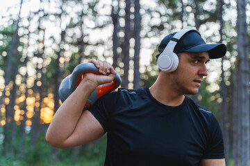 A young man training in the forest during the golden hour stretching and measuring pulse while enjoying nature