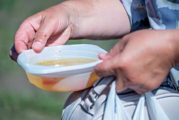 Volunteers distribute food to the poor outdoors, selective focus
