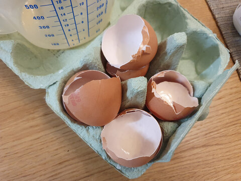 Four broken eggshells in an egg carton packaging having been used as a cooking ingredient and ready to be recycled as food waste