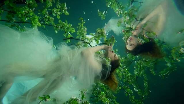 surreal underwater magic shot, young beautiful woman is swimming in fabulous garden