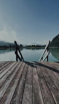 Vertical shot of Achen lake from the wooden dock on blue sky background