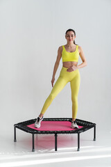 Obraz premium young fitness woman In sportswear jumping on sport trampoline