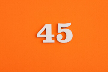 White wooden number 45 on eva rubber orange background
